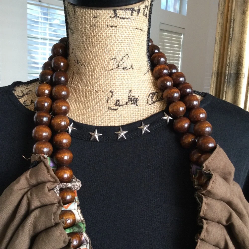 Reversible hobo tote with brown wood balls straps. Has a tie strap closu…